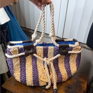 Nautical -themed woven beach tote bag rope handles decorative anchor charm.